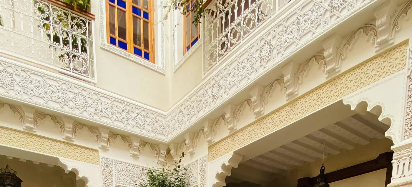 Les galeries des étages, leurs balcons et le plâtre sculpté