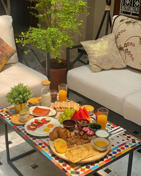 Le petit-déjeuner servi sur une table en zellige dans le patio