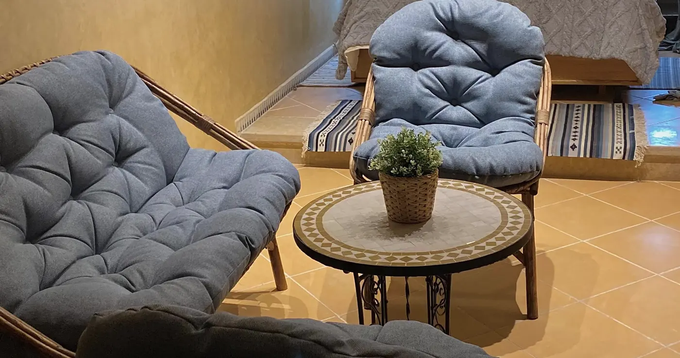 Une chambre, ses fauteuils bleus et le lit