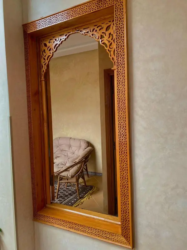 Un miroir dans un cadre de bois sculpté